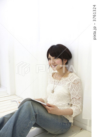 床に座り雑誌を見る女性 3761324