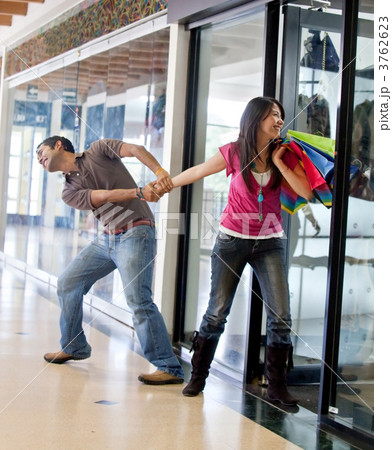 Man keeping a woman from entering a store 3762623