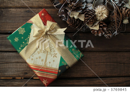 金色のリボンをかけたクリスマスプレゼントとクリスマスリース 3769845