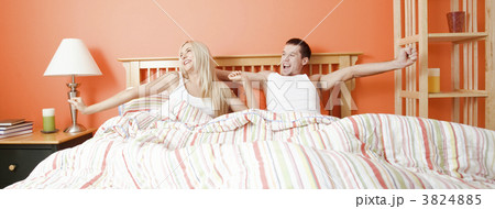 Young Couple Lying in Bed Stretching Young Couple Lying in Bed Stretching 3824885
