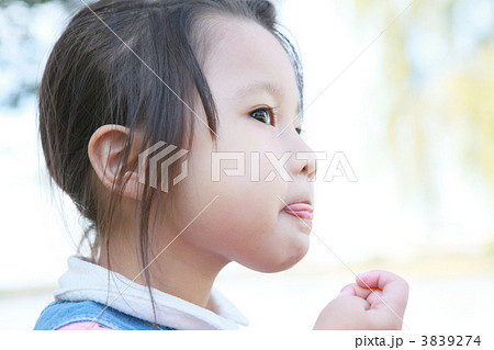 唇をなめる3歳の女の子の写真素材