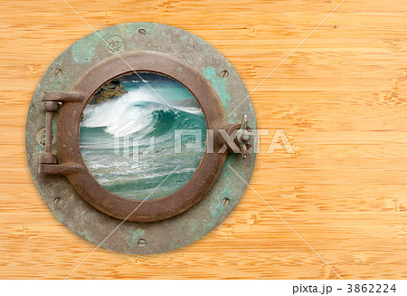 Antique Porthole with View of Crashing Waves on a Bamboo Wall Ba 3862224