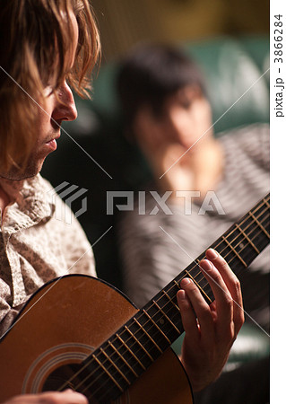Young Musician Plays His Acoustic Guitar as Friend Listens Young Musician Plays His Acoustic Guitar as Friend Listens 3866284