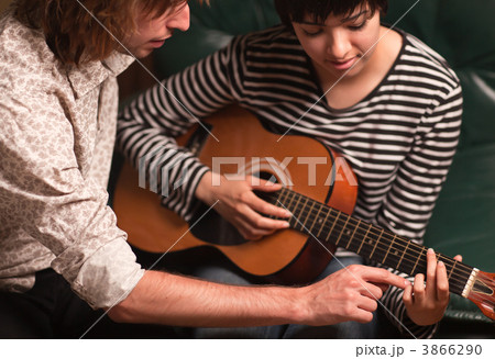 Young Musician Teaches Female Student To Play the Guitar 3866290