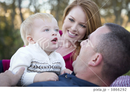 Cute Child Looks Up to Sky as Young Parents Smile 3866292