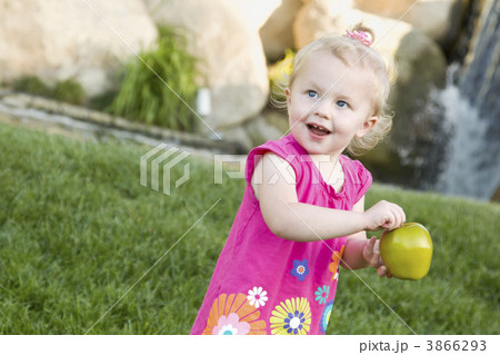 Smiling Young Girl in The Park Holding Apple 3866293
