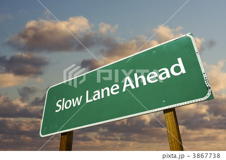 Slow Lane Ahead Green Road Sign Over Clouds Slow Lane Ahead Green Road Sign Over Clouds 3867738