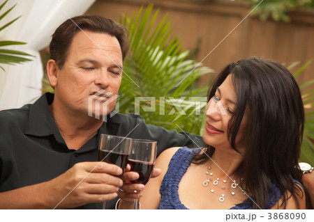 Attractive Hispanic and Caucasian Couple Drinking Wine Attractive Hispanic and Caucasian Couple Drinking Wine 3868090