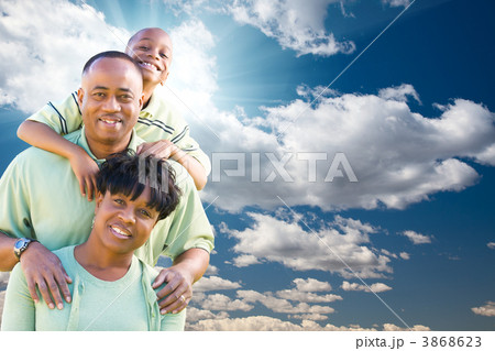 Happy African American Family Over Blue Sky and Clouds Happy African American Family Over Blue Sky and Clouds 3868623