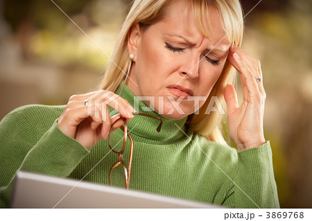 Grimacing Woman Suffering a Headache Grimacing Woman Suffering a Headache 3869768