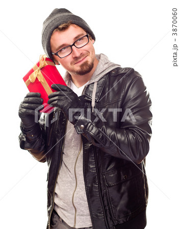 Warmly Dressed Young Man Holding Wrapped Gift To His Ear 3870060