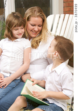 Young Boy Reads to His Mother and Sister 3870499