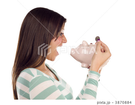 Ethnic Female Putting Coin Into Piggy Bank on White Ethnic Female Putting Coin Into Piggy Bank on White 3870884