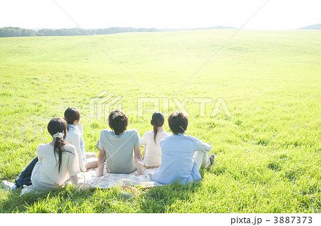 草原に座る若者たちの後姿 3887373