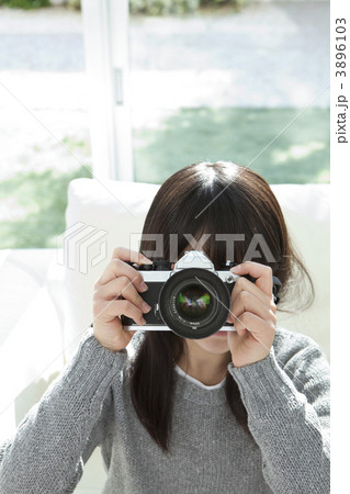 カメラのファインダーをのぞく女の子の写真素材