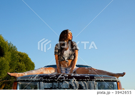 sexy woman washing a car at sunset 3942655