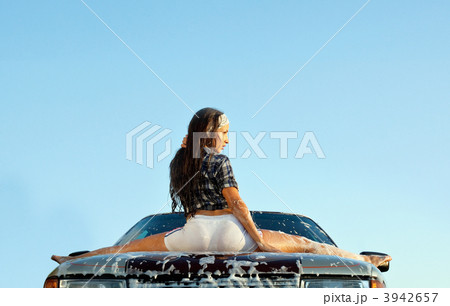 sexy young girl sit on car in foam at sunset 3942657