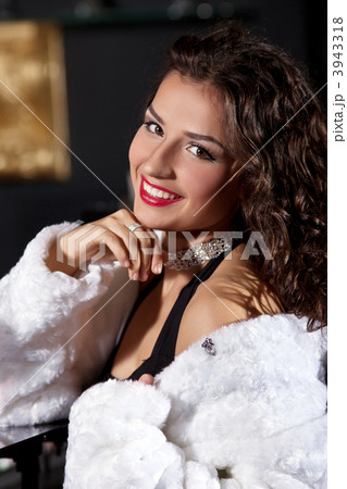 Young woman in white fur coat stand at bar 3943318