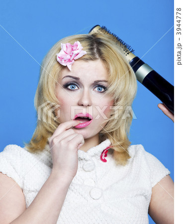 Young blond woman with broken hairdryer 3944778
