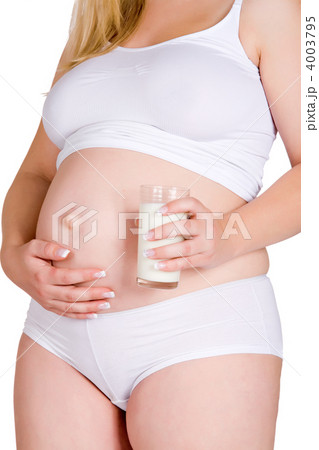 Holding glass of milk juice in front of pregnant belly Holding glass of milk juice in front of pregnant belly 4003795