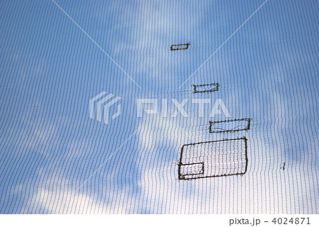 防球ネットのツギハギと青空 4024871