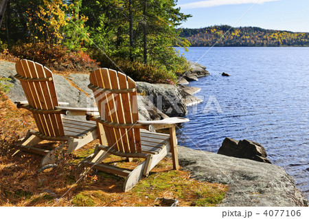 Adirondack chairs at lake shore 4077106