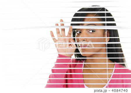 Woman looking through venetian blinds 4084740