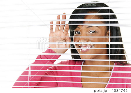 Smiling woman looking through blinds Smiling woman looking through blinds 4084742