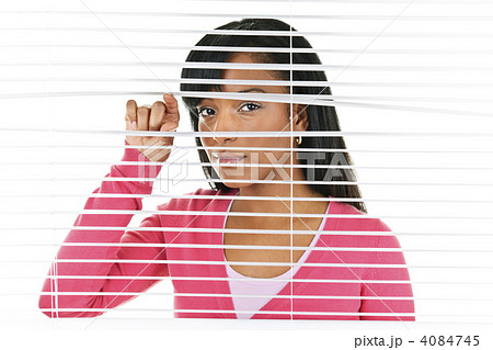 Woman looking through venetian blinds 4084745