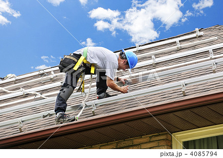 Man working on roof installing rails for solar panels 4085794