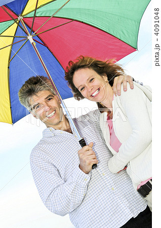 Happy mature couple with umbrella 4091048