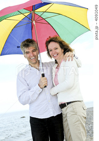 Happy mature couple with umbrella 4091049