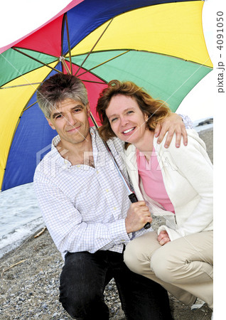 Happy mature couple with umbrella 4091050