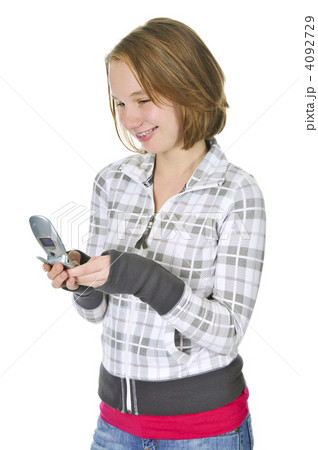 Teenage girl text messaging on a cell phone Teenage girl text messaging on a cell phone 4092729