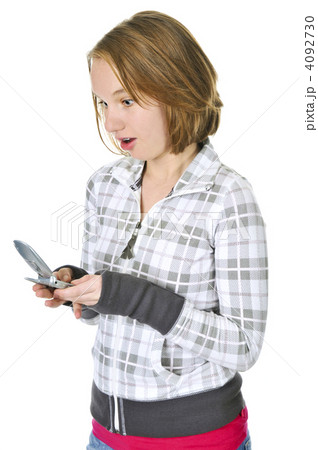 Teenage girl text messaging on a cell phone Teenage girl text messaging on a cell phone 4092730