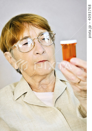 Elderly woman reading pill bottles Elderly woman reading pill bottles 4093768