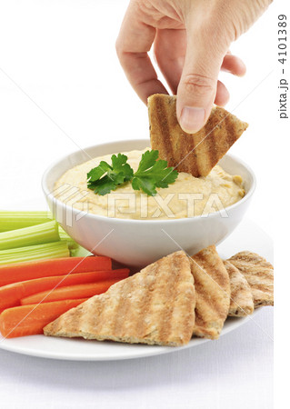 Hand dipping pita in hummus Hand dipping pita in hummus 4101389