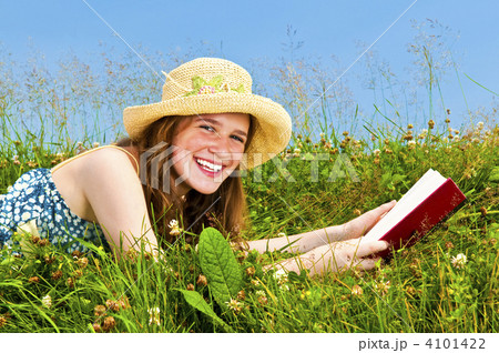 Young girl reading book in meadow 4101422
