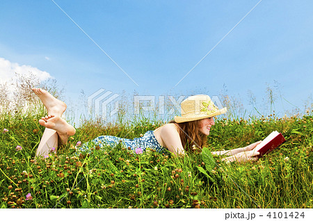 Young girl reading book in meadow 4101424