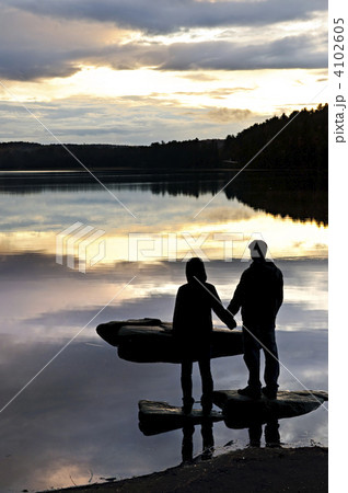 Silhouette of people watching sunset at lake Silhouette of people watching sunset at lake 4102605
