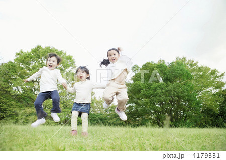 芝生で遊ぶ子供達の写真素材