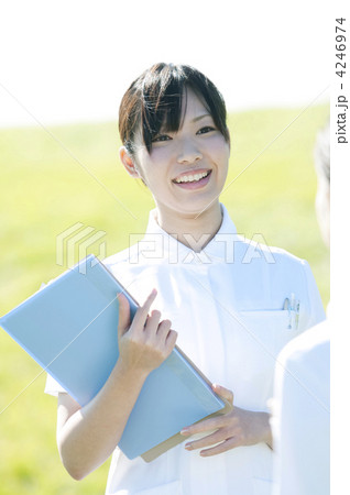 草原でファイルを持ち微笑む看護師 4246974