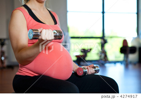 Pregnant woman exercising with weights 4274917