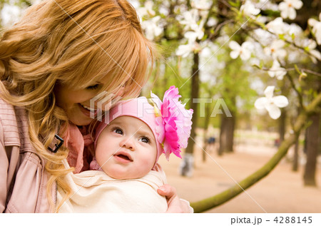 Beautiful young mother and baby daughter having fun outdoors at 4288145