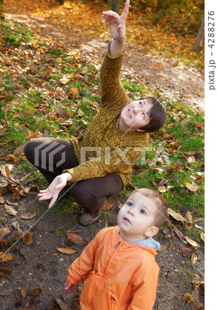 Mother and son in autumn forest, looking at plane in the sky Mother and son in autumn forest, looking at plane in the sky 4288276