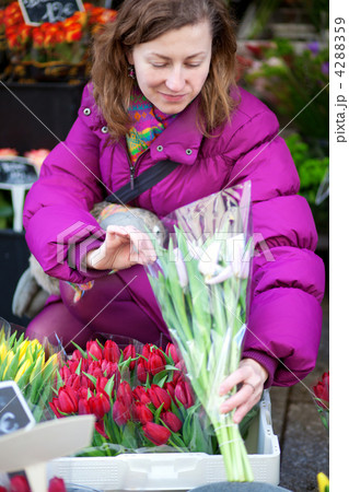 Beautiful young woman selecting flowers at market 4288359