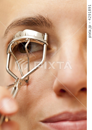 portrait of young woman using an eyelash curler 4291891