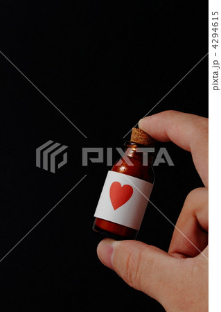 ハートマークのラベルの茶色の小瓶を持つ手 4294615