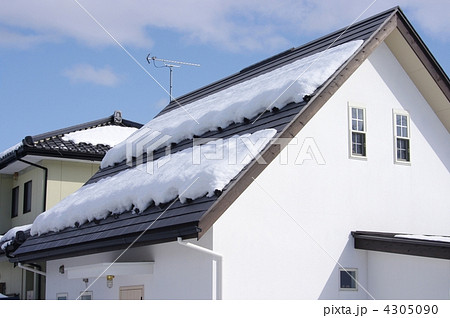 雪積もる屋根 落雪防止対策の屋根 雪対策用の屋根の写真素材