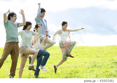草原でジャンプする若者たちの写真素材